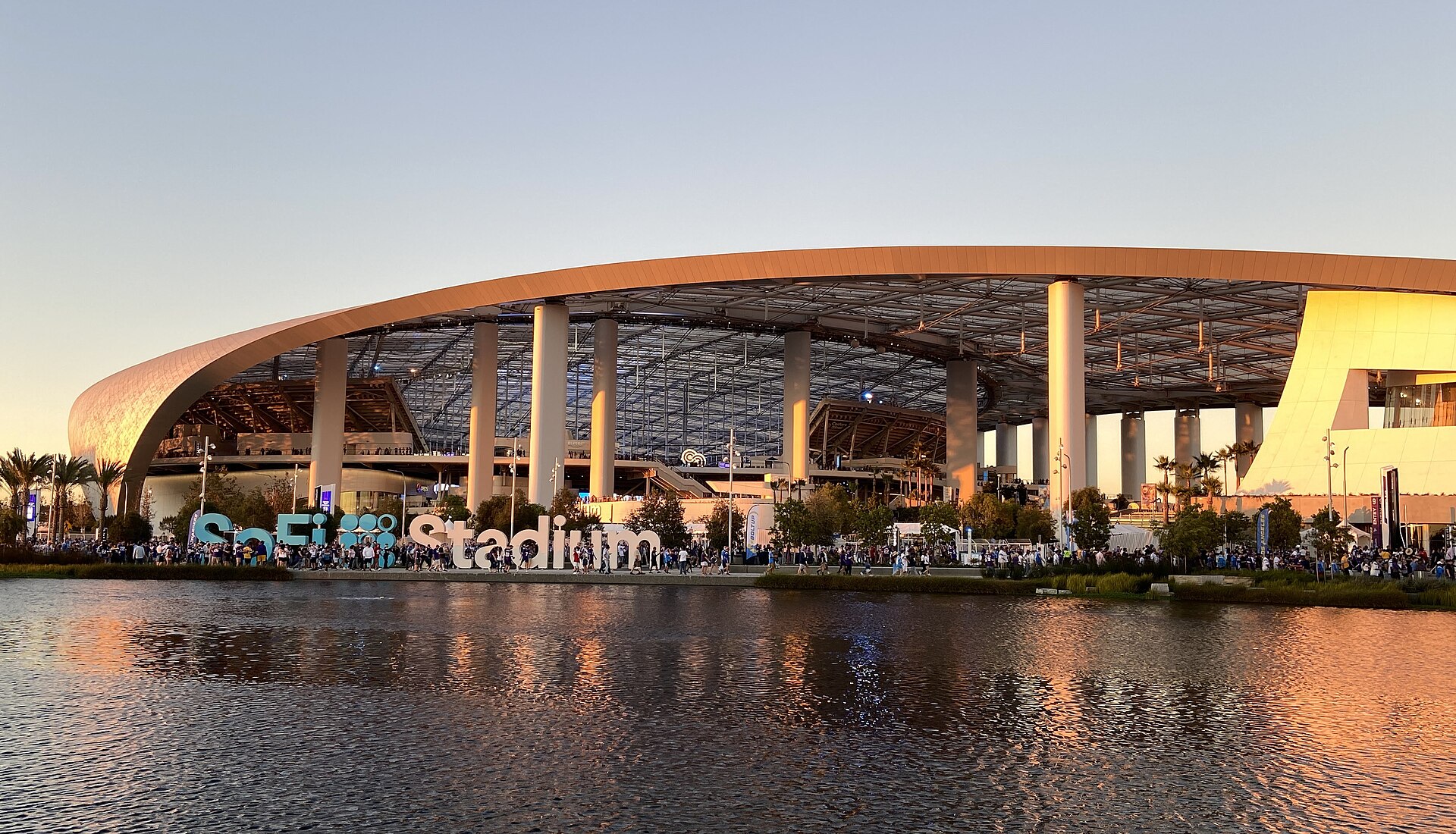 Exterior of SoFi Stadium at sunset, reflected in the lake in front of it
